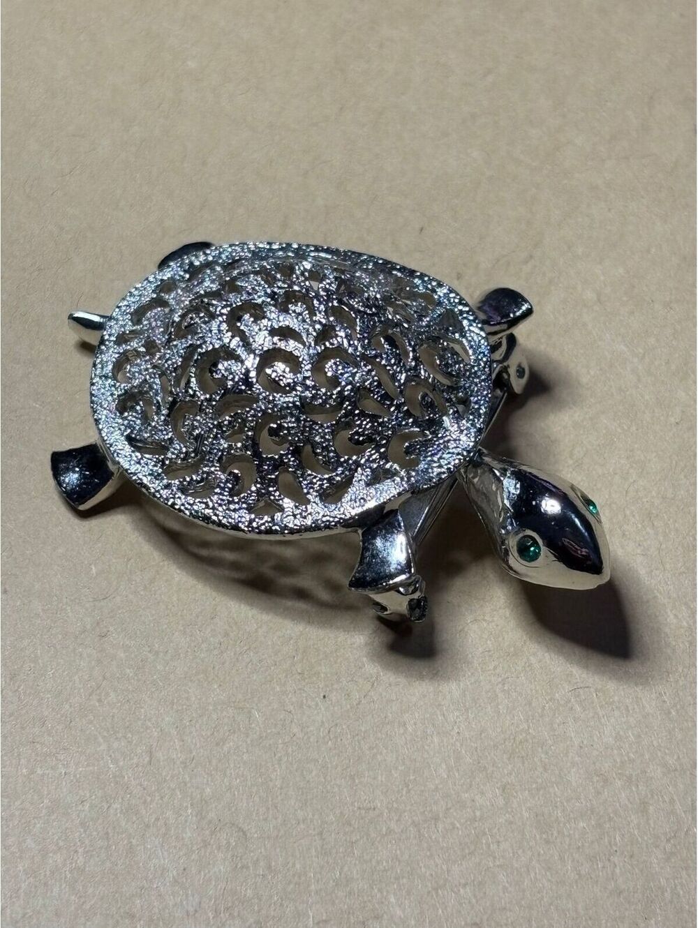 Elegant silver turtle brooch intricate detailing and green accent stones. JJ
